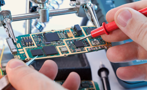 Electronic technician works on a computer board.